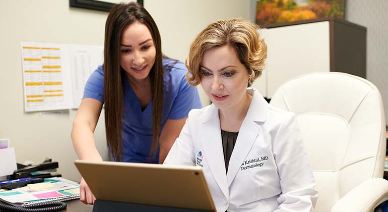 Doctor and nurse looking at laptop screen
