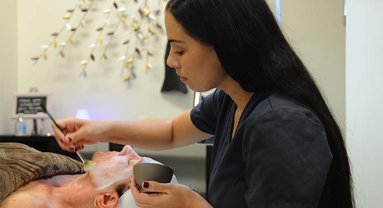 Nurse applying facial treatment to patient