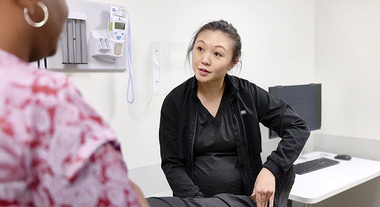 Doctor speaking with patient while examining legs