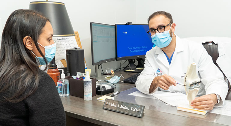 doctor talking with patient at a desk