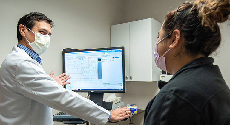 Doctor talking with patient looking at results on computer screen