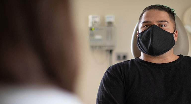 Male patient speaking with medical professional 