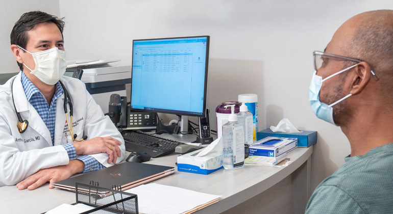 doctor talking to patient across table in office