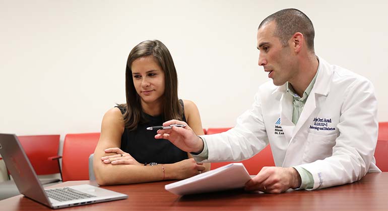 Image of doctor and patient looking at laptop 