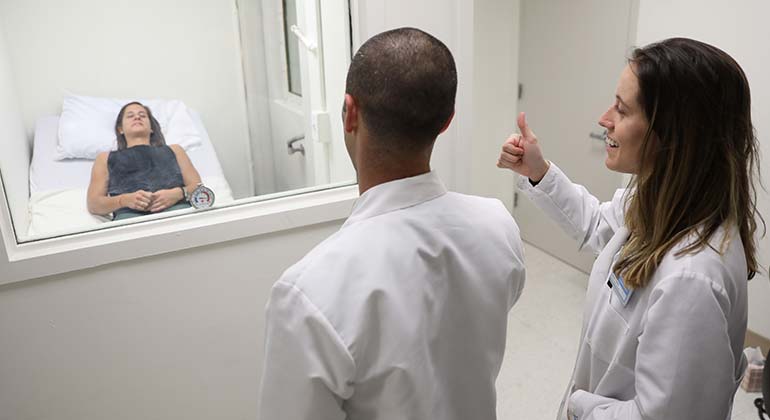 Image of doctors looking at patient in room