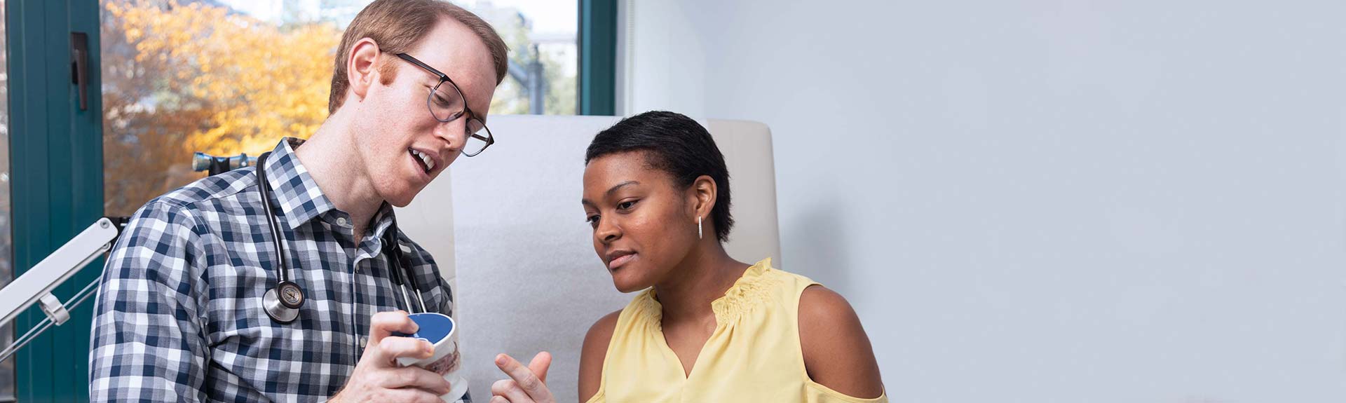 Doctor pointing to model of a mouth and explaining to patient