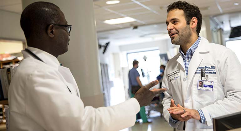 Two doctors talking in a hallway