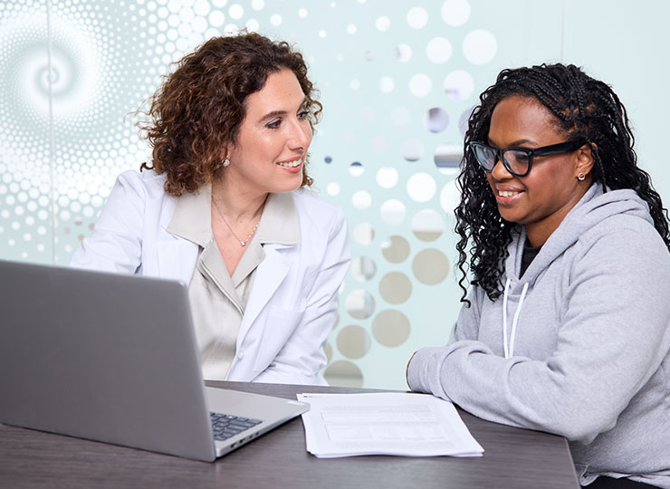 Photo of doctor and patient talking in front of a laptop