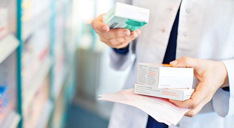 Pharmacist examines medicine labels