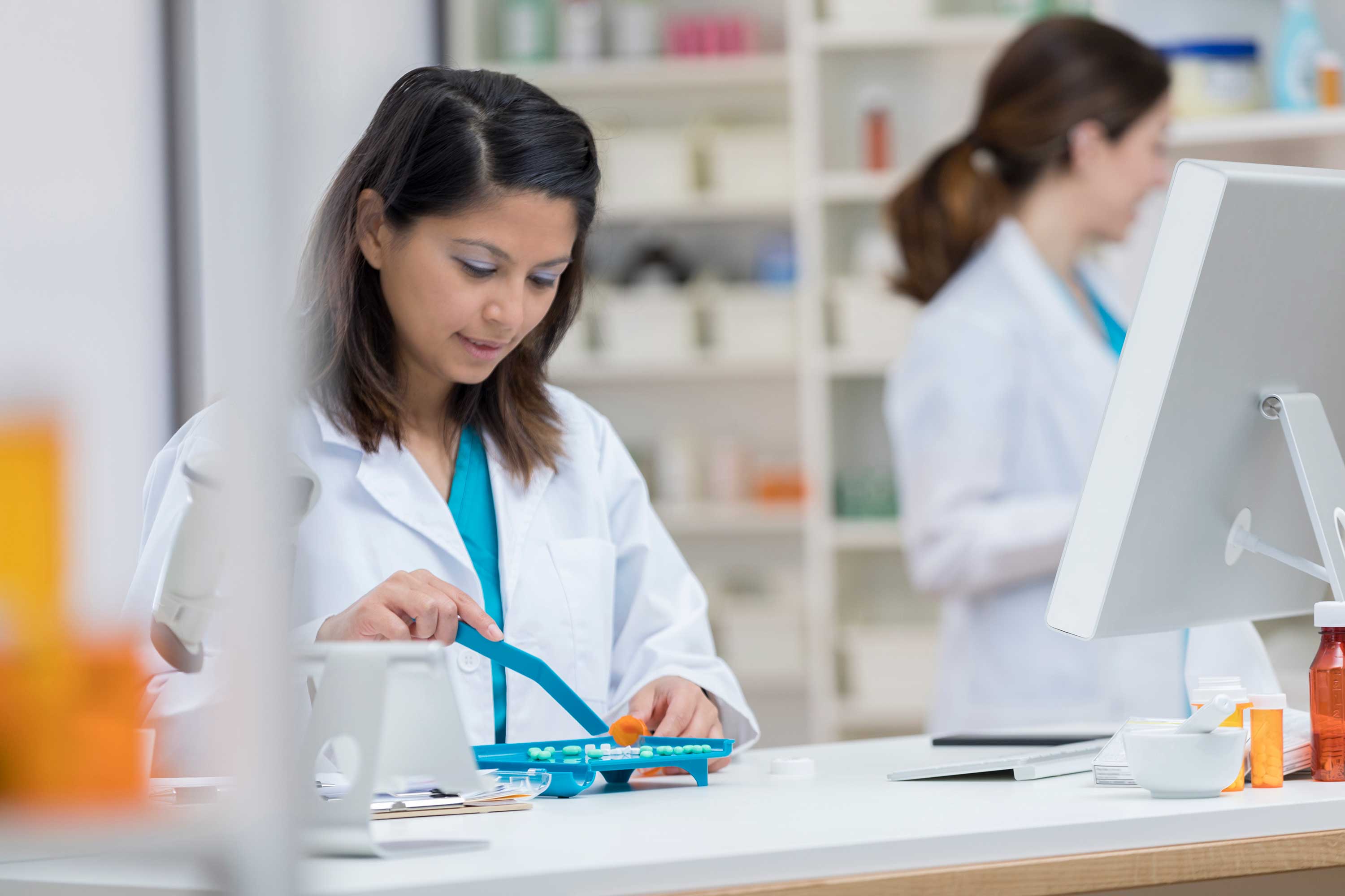 Pharmacist dividing medicine in tray