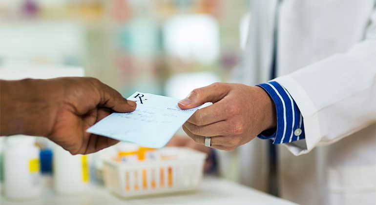 Patient gives pharmacist a prescription slip