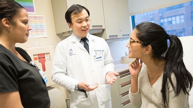 Smiling doctor with nurse and patient