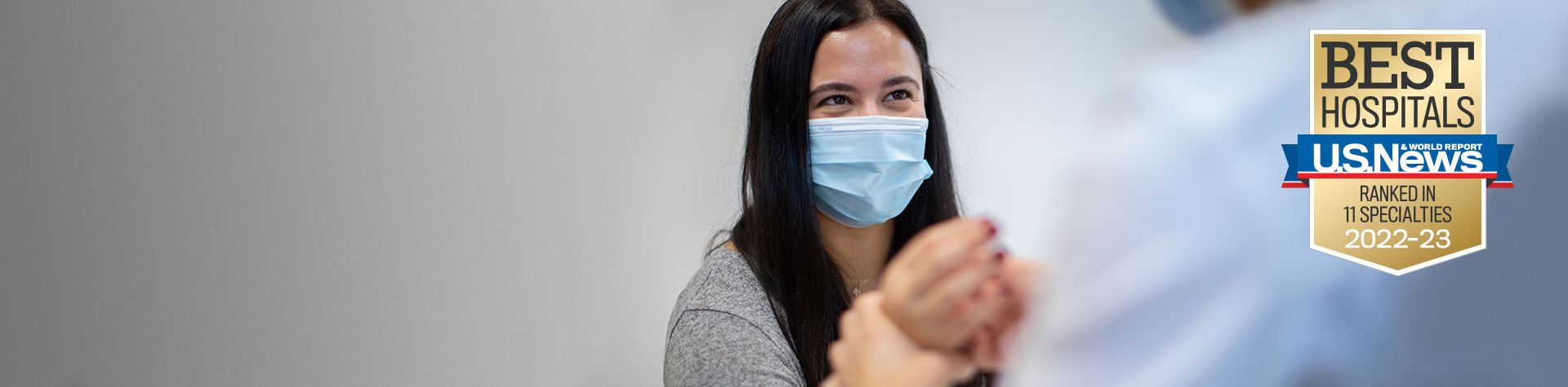 Patient with a mask and US News badge