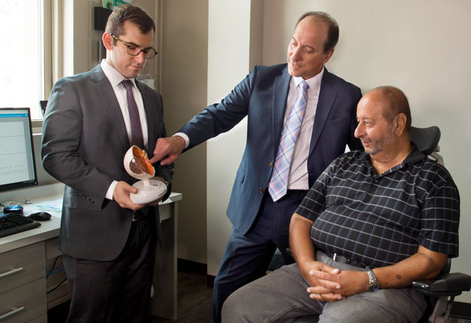 A photo showing Richard Kaplan, MD, a vitreoretinal surgery fellow at NYEE and Ronald Gentile, MD, with patient Joe Mauro explaining the new procedure for eye injections.