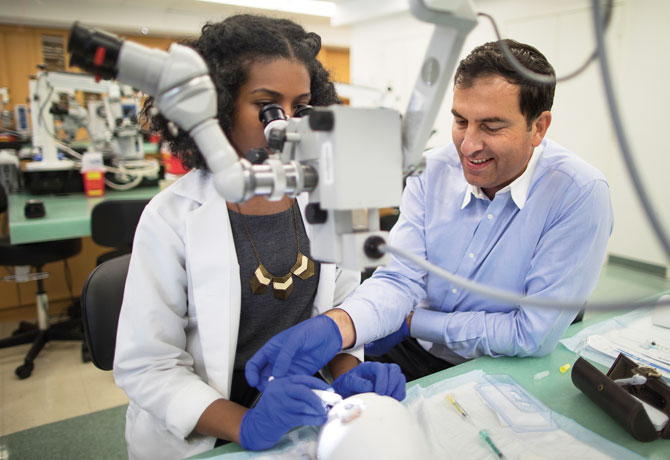 A phot showing Dr. Ianchulev teaching Duaa Sharfi, MD, a NYEE resident, how to use the miLOOP device at Jorge N. Buxton, MD Microsurgical Education Center.