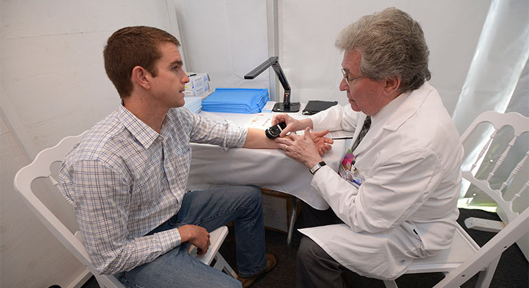 Norman Goldstein, MD, performing a skin cancer screening at the Mount Sinai Health Concourse