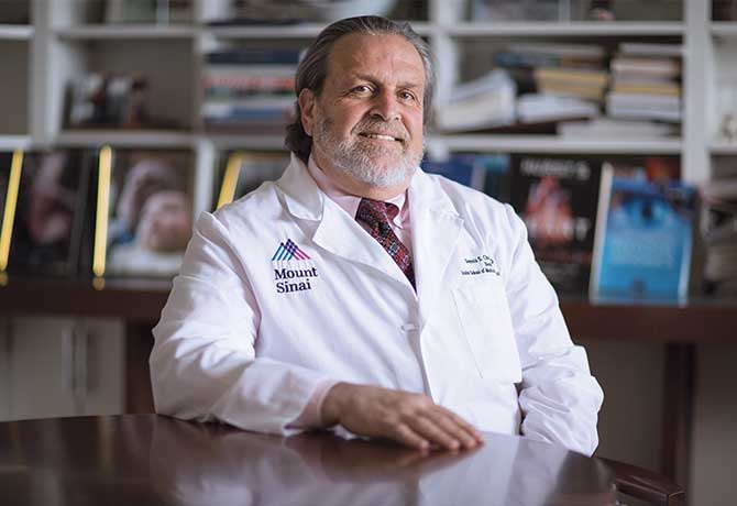 Photo of Dennis Charney, MD sitting at desk