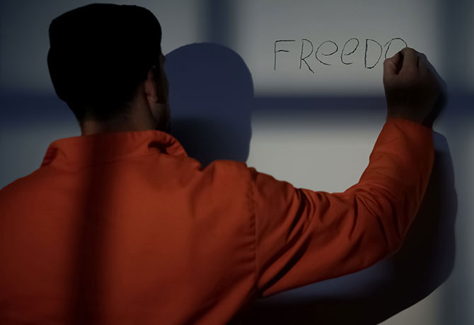 A photo showing a person writing the word “freedom” on a white board.