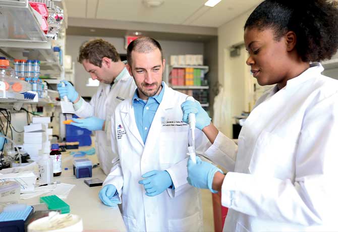 A photo showing Jeremiah Faith with graduate students Joshua Borgerding and Justine Noel