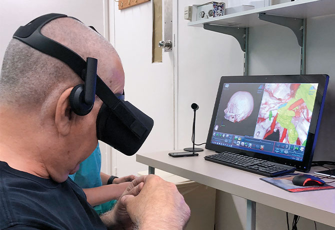 Figure 2: A photo showing Patient David Wendrow, wearing a virtual reality headset, who was able to see a 3D visualization of his anatomy during his pre-surgery simulation consultation visit.