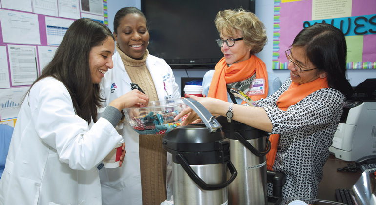 A pair of volunteers give a pair of doctors snacks during Chi time