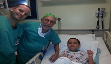 Photo of patient Grant Rechen in hospital bed with doctors