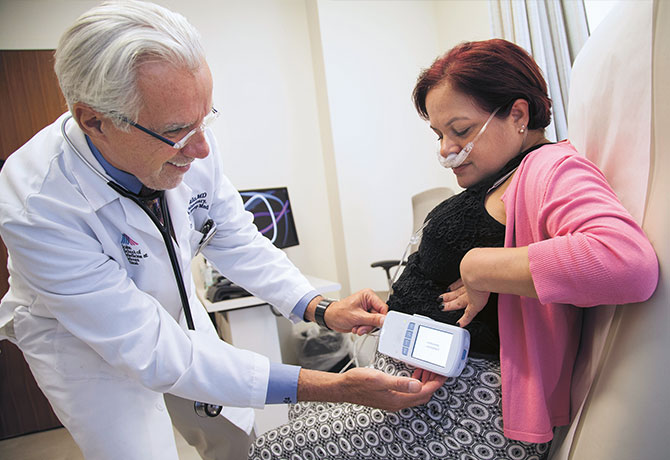 Image of Louis DePalo, MD, demonstrating the Life2000™ portable positive pressure ventilator system with a staff member