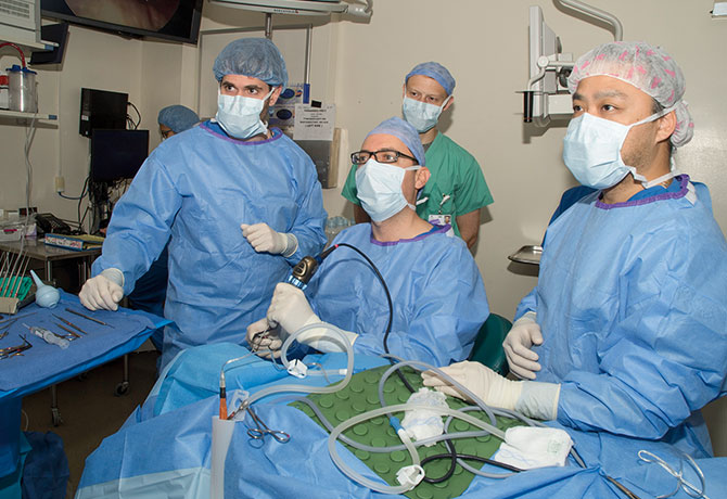Photo of Jonathan C. Garneau, Benjamin M. Laitman, and Edmund Nahm performing the endoscopic tumor-removal procedure developed by George Wanna, MD
