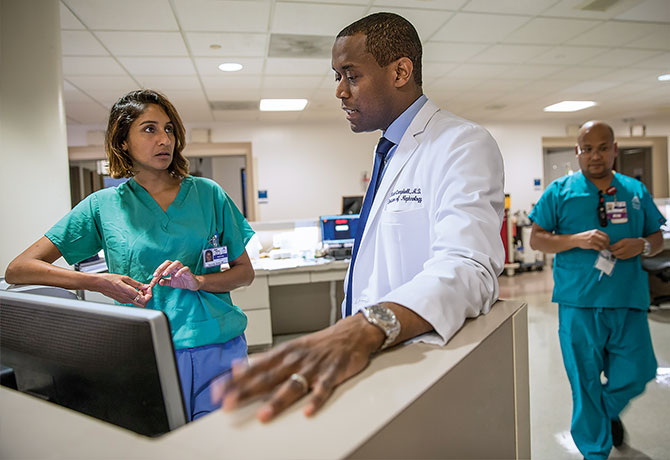 A photo shows Karendip Kaur Braich, MD, reviewing a chart with Kirk Campbell, MD.