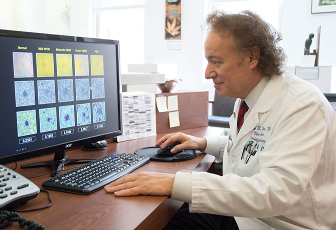 A photo showing Richard Rosen, MD, reviewing OCT angiography comparison study.