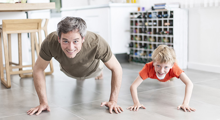 father and son are doing push-ups and having fun at home