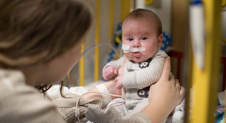 Mom holding baby in NICU