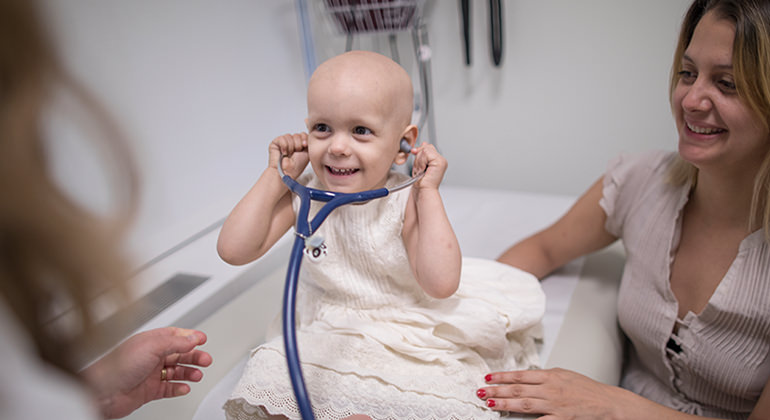 Young girl playing with stethoscope on examining table
