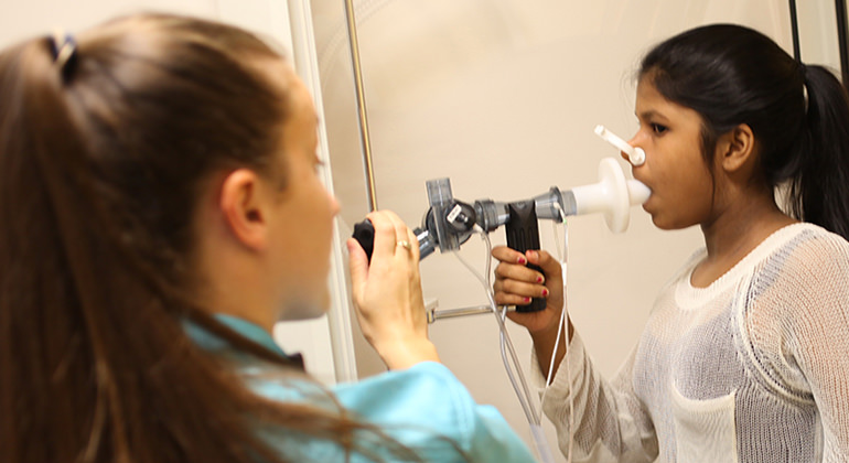 Female pulmonology patient breathing into machine