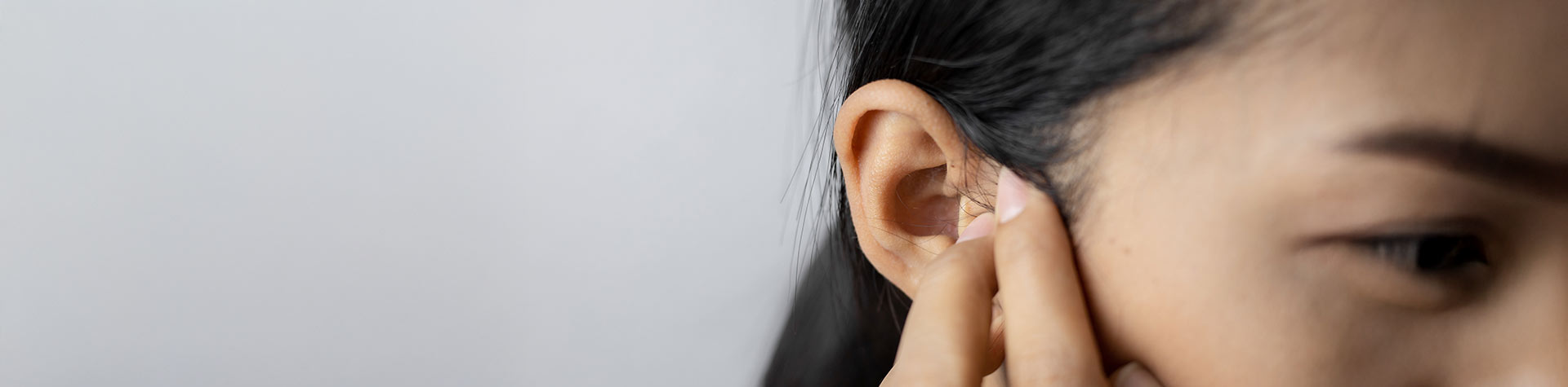person holding their ear