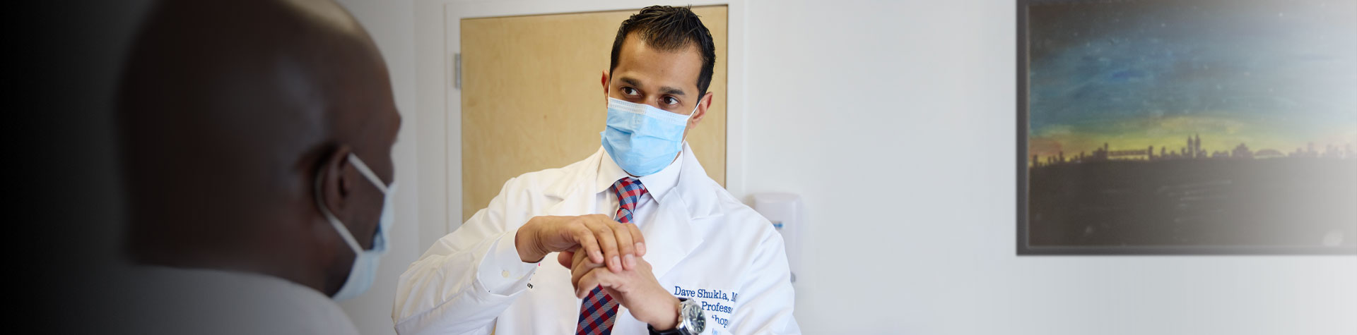 Patient having shoulder examined by physician