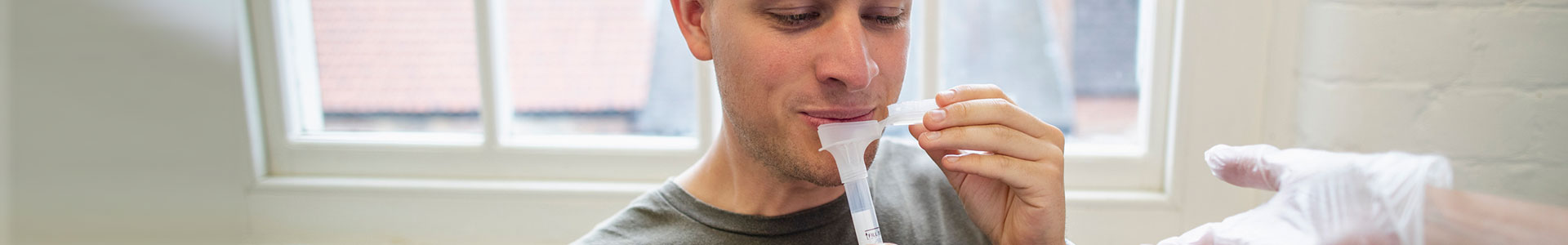 Image of person spitting in tube