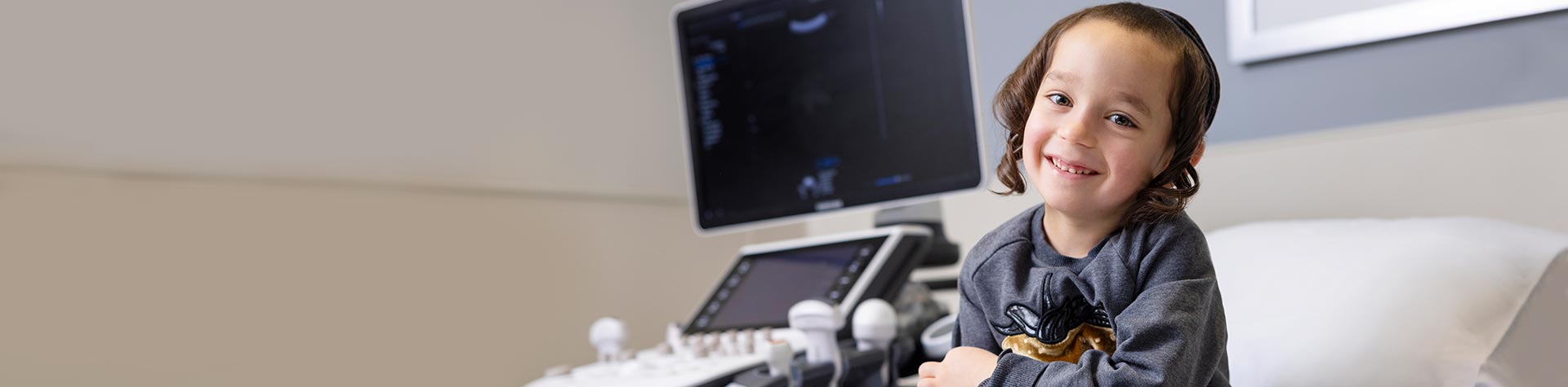 Toddler patient, smiling in Kravis Children Heart Center exam room