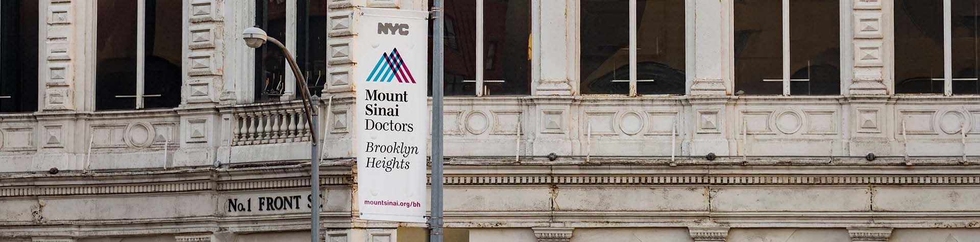 NYC and Mount Sinai Doctors Brooklyn Heights flag on a flagpole in front of the Hamerman building