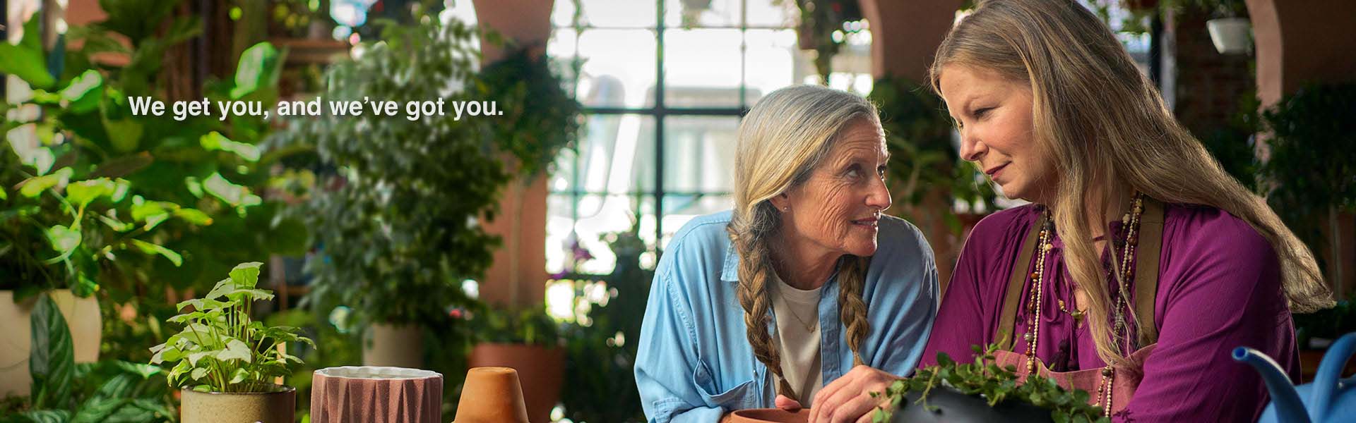 a somber patient in a room full of plants being comforted