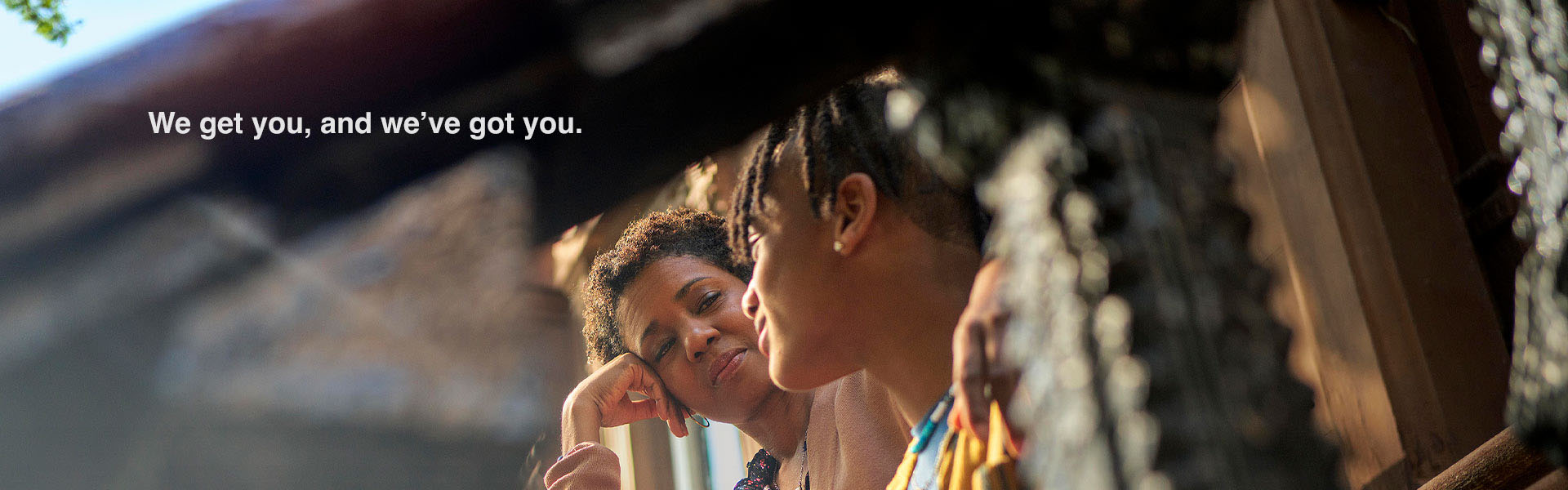 woman attentively to a boy sitting on steps during a conversation