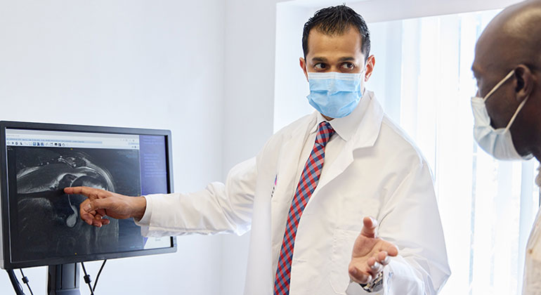 doctor going over findings on a monitor with patient