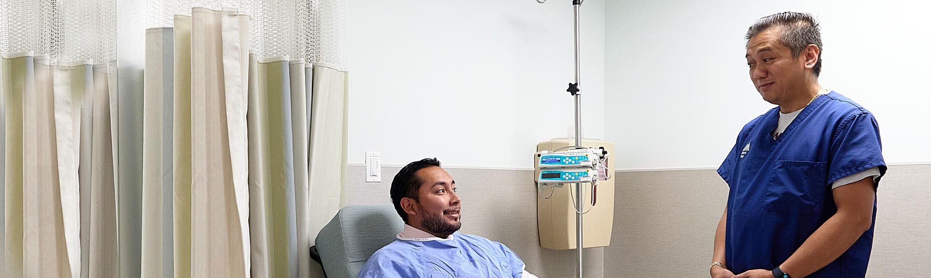 patient seated across from doctor standing nearby