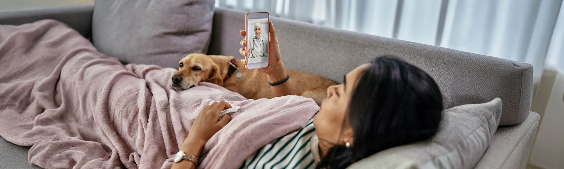 patient with dog on mobile phone with doctor via an On-Demand Virtual Urgent Care Video Visit