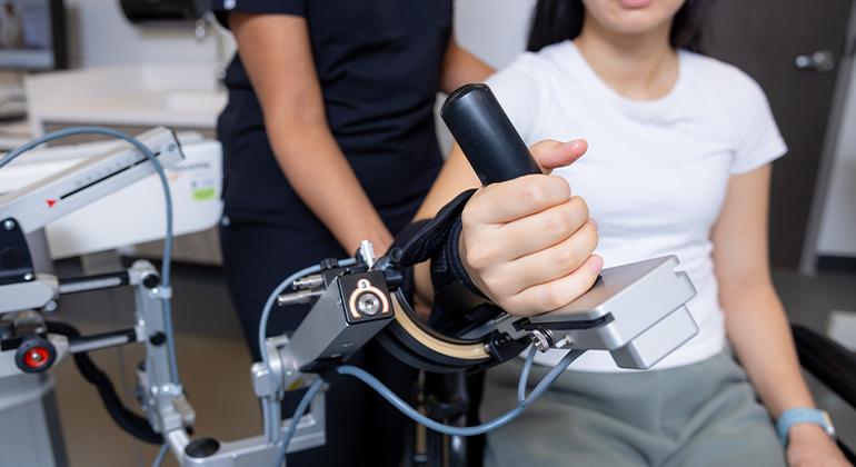 patient using rehab equipment to improve hand function