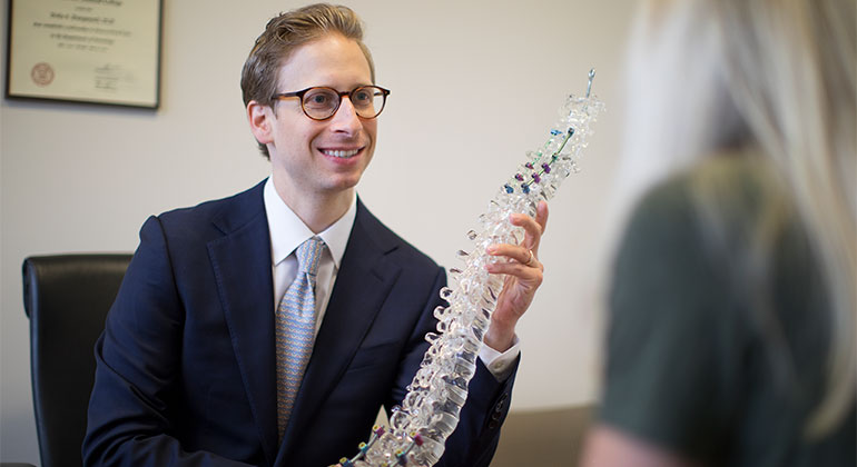 Doctor with model of spine