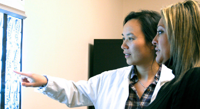 Image of Dr. Zou reviewing brain scans with patient