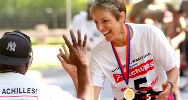 Trisha Meili giving a high 5 to a runner