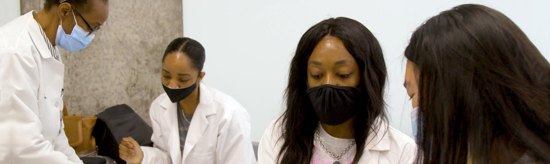 Nursing students sitting at a table administering a vaccine
