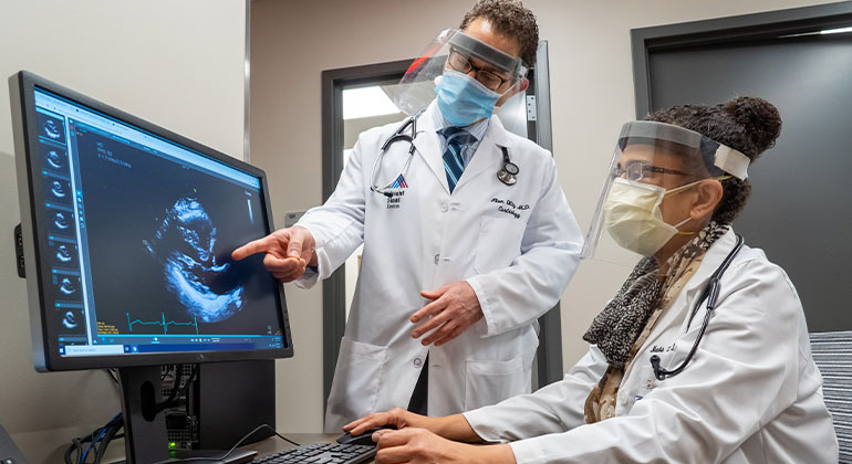 Masked doctors looking at computer